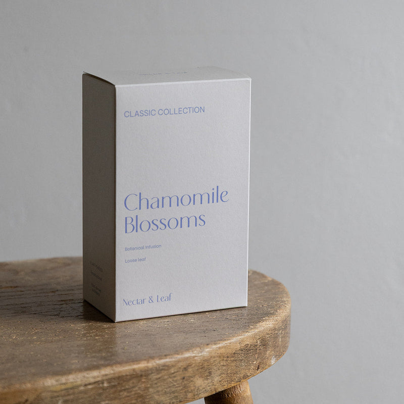 Box of 'Chamomile Blossoms' from Nectar & Leaf on a wooden table with a gray background
