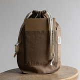 Brown drawstring bag with visible branding on a gray background