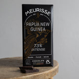Meurisse Papua New Guinea 73% intense dark chocolate bar on a wooden stand with a gray background