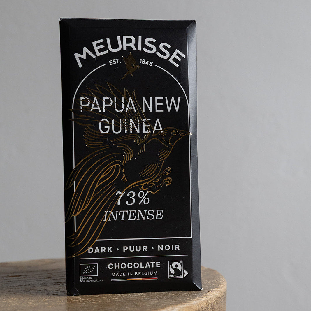 Meurisse Papua New Guinea 73% Intense dark chocolate packaging on a wooden stool with a gray background