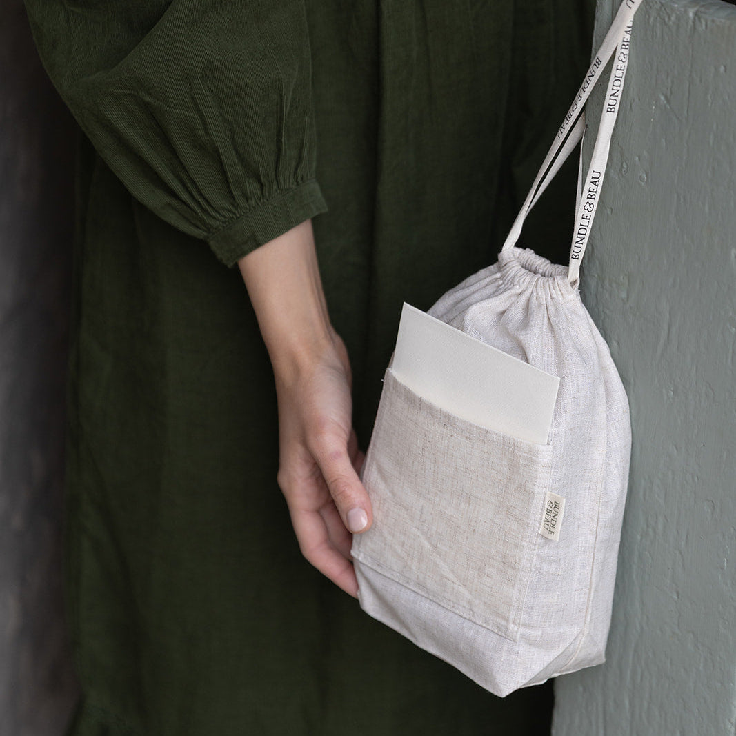 Person holding a drawstring bag against a dark background