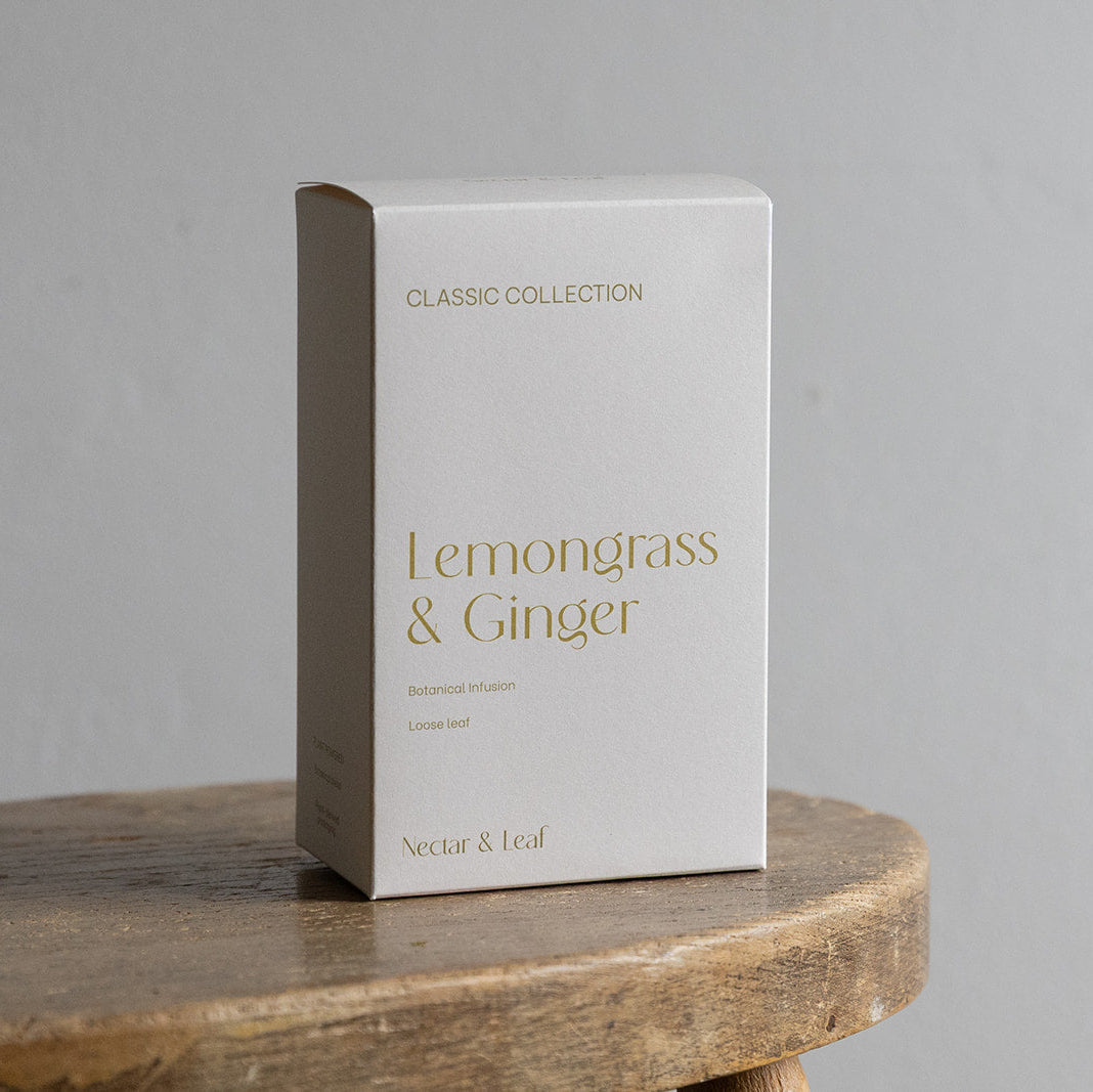 White box labeled 'Lemongrass & Ginger' on a wooden surface with a gray background